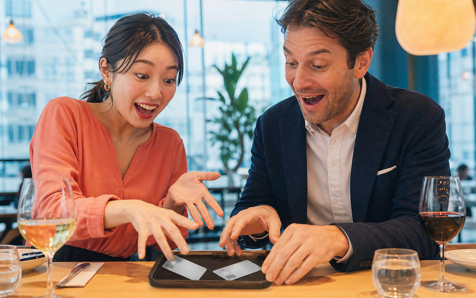 Two adults cheerfully discussing a restaurant bill in a bright Tokyo cafe